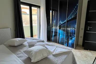 a bed with pillows in a room with a window at Anna Kavros luxury apartment in Chania Town