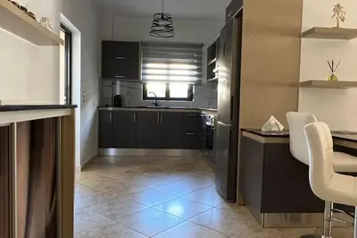 a kitchen with a black refrigerator and a table and chairs at Anna Kavros luxury apartment in Chania Town