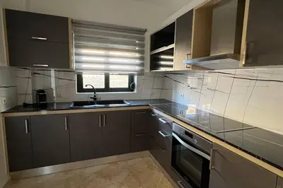 a kitchen with brown cabinets and a sink and a stove at Anna Kavros luxury apartment in Chania Town