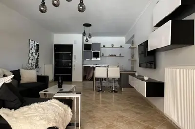a living room and kitchen with a couch and a table at Anna Kavros luxury apartment in Chania Town