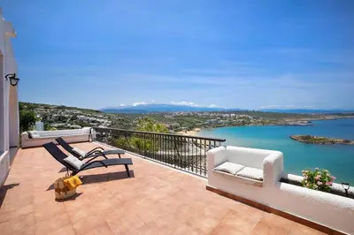 a balcony with chairs and a view of the water at Casa Bella Vista in Kalathas