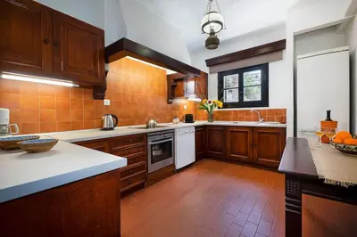 a large kitchen with wooden cabinets and white appliances at Casa Bella Vista in Kalathas