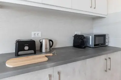 a kitchen counter with a microwave and a cutting board at Katofli Slow Living in Pithárion