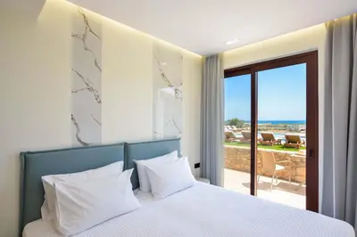 a bedroom with a bed with a view of the ocean at Panthea Luxury Living in Kolymvari