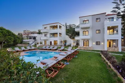 an exterior view of a building with lounge chairs and a pool at Panthea Luxury Living in Kolymvari