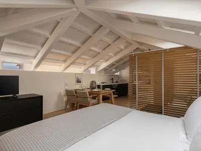 a bedroom with a bed and a table with chairs at La Torre del Kastelli in Chania Town