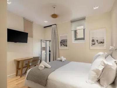 a bedroom with a bed and a desk and a television at La Torre del Kastelli in Chania Town