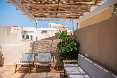 a patio with two chairs and a plant on a building at La Torre del Kastelli in Chania Town