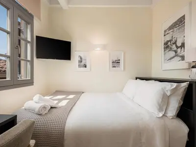a bedroom with a bed with a tv on the wall at La Torre del Kastelli in Chania Town
