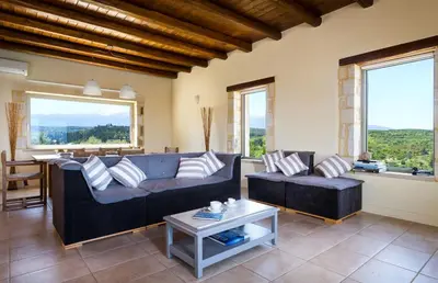 a living room with a couch and a table at Villa Asteriskos in Áyios Andhréas
