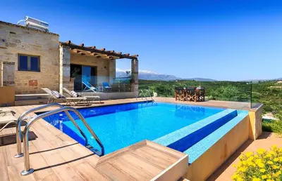 a villa with a swimming pool and a house at Villa Asteriskos in Áyios Andhréas