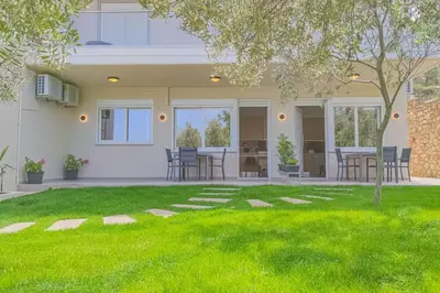 a house with a yard with green grass at Renovated apartment 3- Platanias in Plataniás
