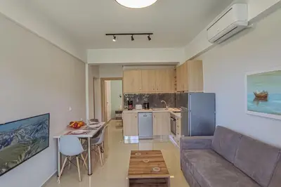 a kitchen and a living room with a couch and a table at Renovated apartment 3- Platanias in Plataniás