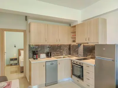 a kitchen with wooden cabinets and a stainless steel refrigerator at Renovated apartment 3- Platanias in Plataniás