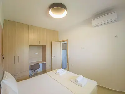 a bedroom with two white beds and a chair at Renovated apartment 2 -Platanias in Plataniás