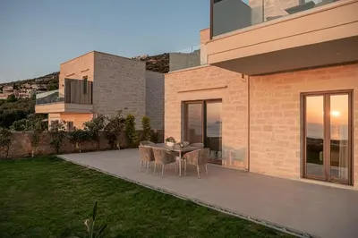 a patio with a table and chairs next to a building at GG Villas Falassarna in Chania Town