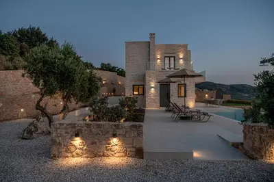 a stone house with a courtyard and a pool at GG Villas Falassarna in Chania Town
