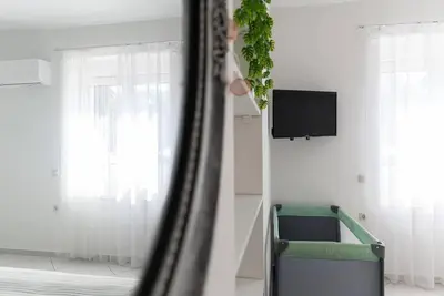 a living room with a television and a green chair at Casa Valore central with parking by 8essentially in Chania Town