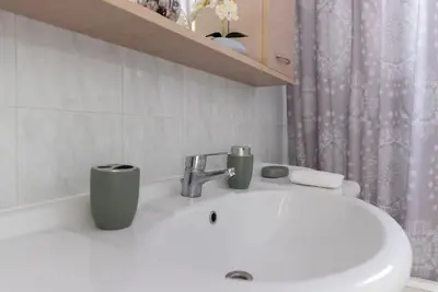 a bathroom sink with two cups on top of it at Casa Valore central with parking by 8essentially in Chania Town