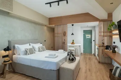 a bedroom with a large white bed and a table at Nomas lifestyle living in Chania Town