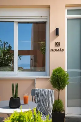 a window of a building with a table and potted plants at Nomas lifestyle living in Chania Town