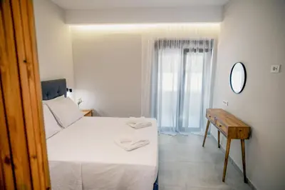 a bedroom with a bed and a table and a mirror at Sweven boutique apartments in Souda