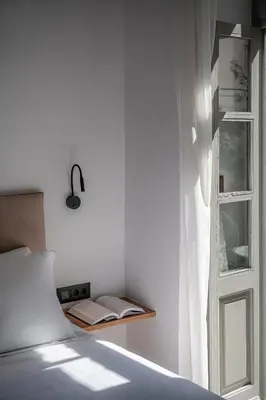 a white bedroom with a bed and a window at Porto Vecchio in Chania Town
