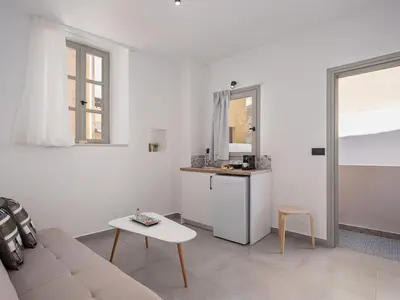 a white living room with a couch and a table at Porto Vecchio in Chania Town