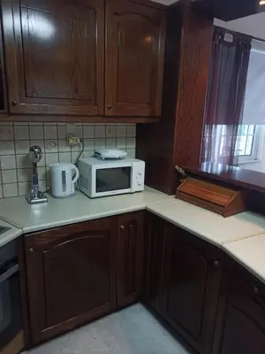 a kitchen with wooden cabinets and a microwave on the counter at Giannis House in Kissamos in Kissamos
