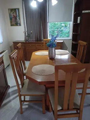 a wooden table with chairs and a vase of flowers on it at Giannis House in Kissamos in Kissamos