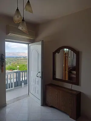 a bathroom with a mirror and a door with a view at Giannis House in Kissamos in Kissamos