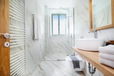 a white bathroom with a sink and a mirror at Casa Verde Chania in Chania Town
