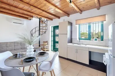a kitchen and dining room with a table and chairs at serenissimo A&A in Galatás