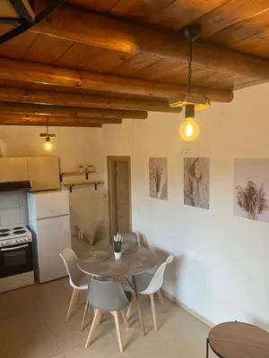 a kitchen and dining room with a table and chairs at serenissimo A&A in Galatás