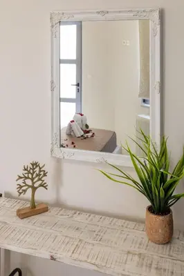 a mirror on top of a table with a plant at Christini Cozy Apartment in Souda