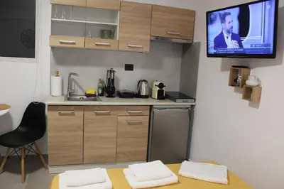 a kitchen with a tv on the wall and a table at Angel's Nest in Chania Town