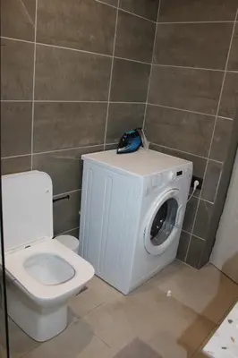 a bathroom with a toilet and a washing machine at Angel's Nest in Chania Town