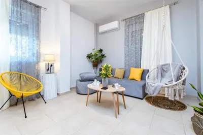 a living room with a blue couch and a table at Nikola's Vineyard in Ayiá