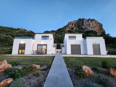 a white house with a mountain in the background at Isabel Artemis Crete - Luxury Sea Views Villas in Nopíyia