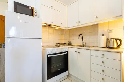 a kitchen with white cabinets and a white refrigerator at Koum Kapi Mare Studios B2 in Chania Town