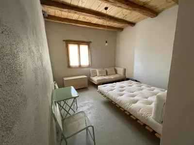 a living room with a large bed and a couch at Petres old village house in Áyios Ioánnis
