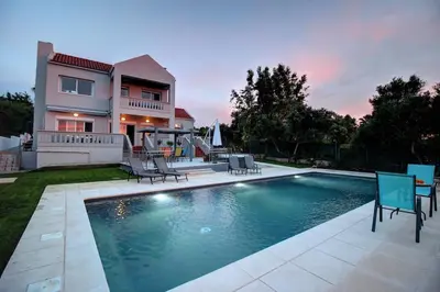 a house with a swimming pool in front of a house at Mabech Villa in Plataniás