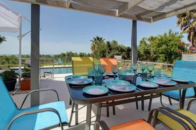 a table with glasses and plates on a patio at Mabech Villa in Plataniás