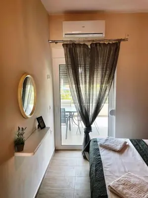 a bedroom with a bed and a window with a patio at Korina's Apartment in Daratso
