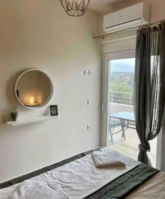 a bedroom with a bed and a mirror and a balcony at Korina's Apartment in Daratso