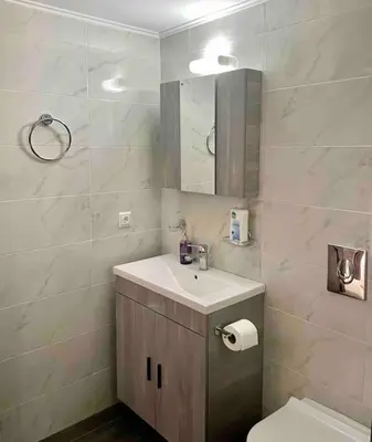 a bathroom with a sink and a toilet and a mirror at Korina's Apartment in Daratso