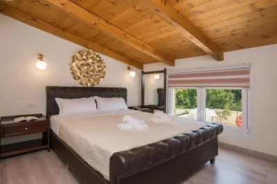 a bedroom with a large bed and a large window at Garden Villa Chania in Chania Town