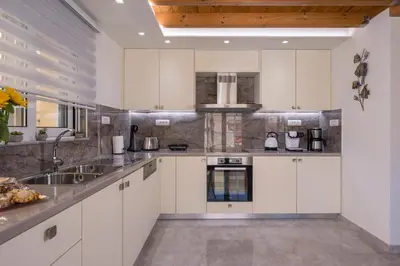 a kitchen with white cabinets and a sink at Garden Villa Chania in Chania Town