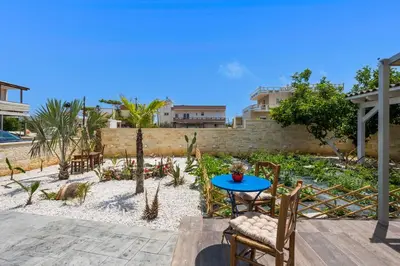 a patio with a table and chairs in a yard at Garden Villa Chania in Chania Town