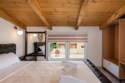 a bedroom with a large bed and a window at Garden Villa Chania in Chania Town